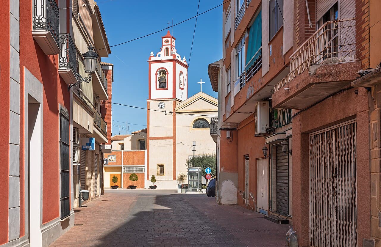 Straatzicht op de kerktoren van Rojales vanaf de Calle Joaquín González